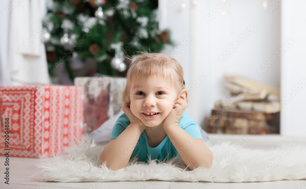 little girl lying on floor near Christmas tree. little girl lying on floor near Christmas tree.