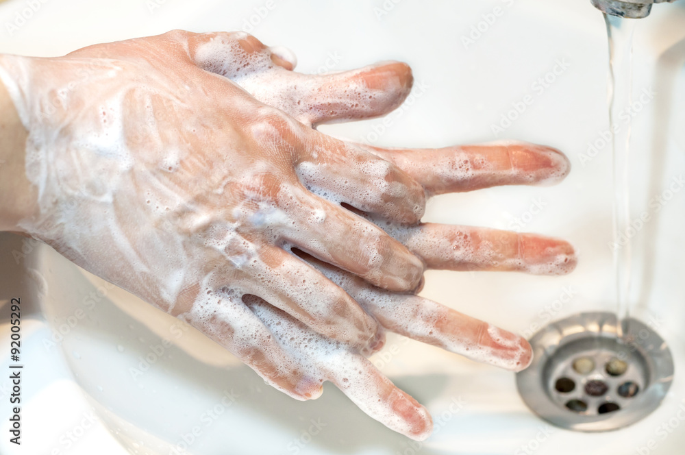 Washing of hands with soap under running water, close up Washing of hands with soap under running water, close up