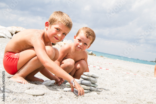 happy little brothers playing on the beach