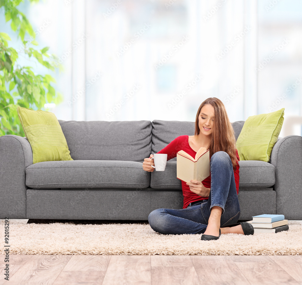 Brunette woman reading a book and drinking coffee