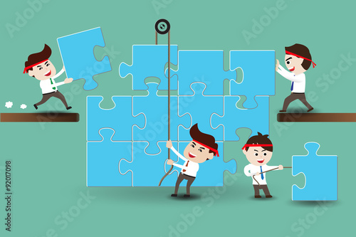 Teamwork, business men assembling pieces of a puzzle