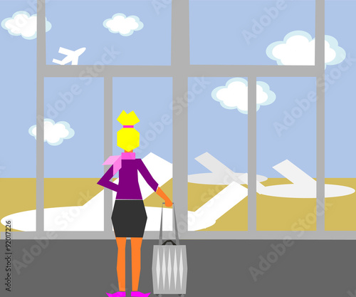 A stewardess standing in the airport and looking at the planes