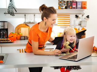 Mother with daughter in halloween bat costume having video chat