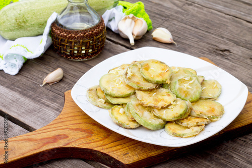 Fried zucchini with garlic in a bowl on a table
