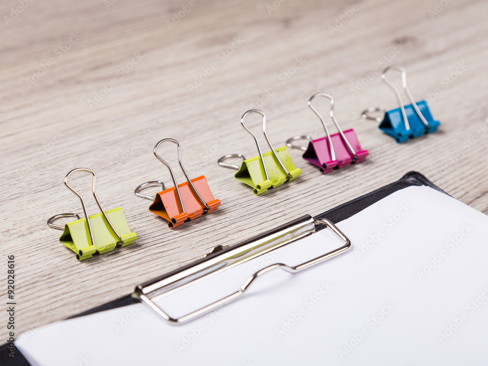 Fototapeta premium colorful paper clip on wood background