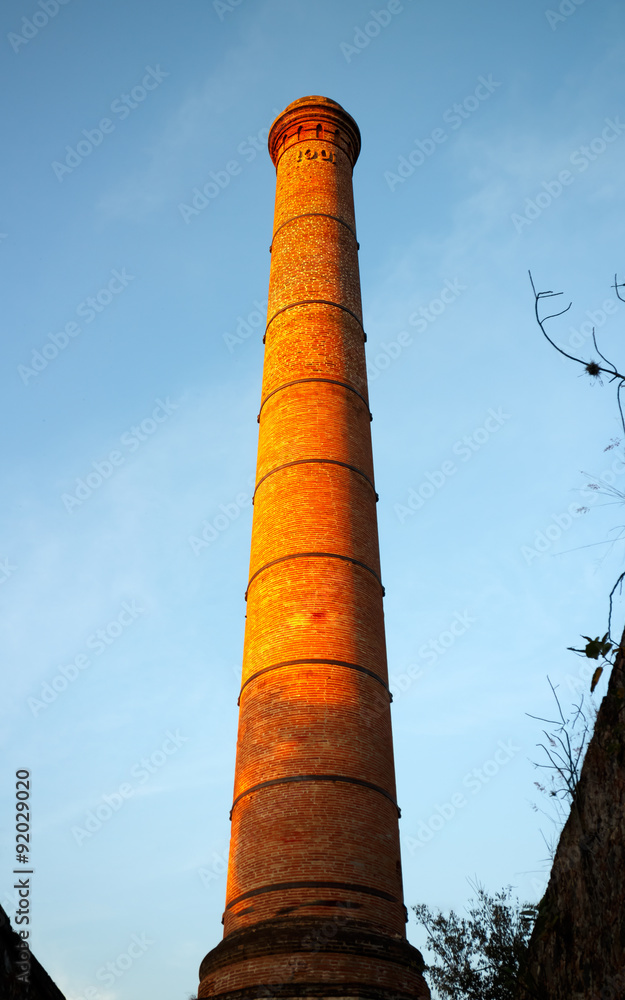 Chimney in blue sky at sunset.