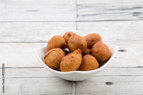 Popular Malaysian fritter snack deep fried banana balls or locally known as Cekodok Pisang in white bowl