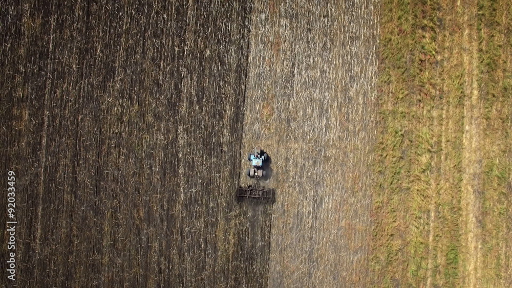 Aerial: Tractor plowing the soil. Top view. Aerial: Tractor plowing the soil. Top view.