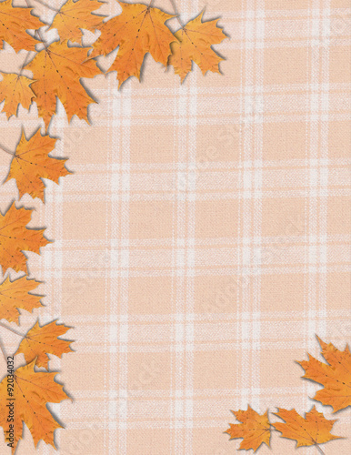 Photo frame of fall autumn maple leaves on an orange plaid background for Halloween Thanksgiving