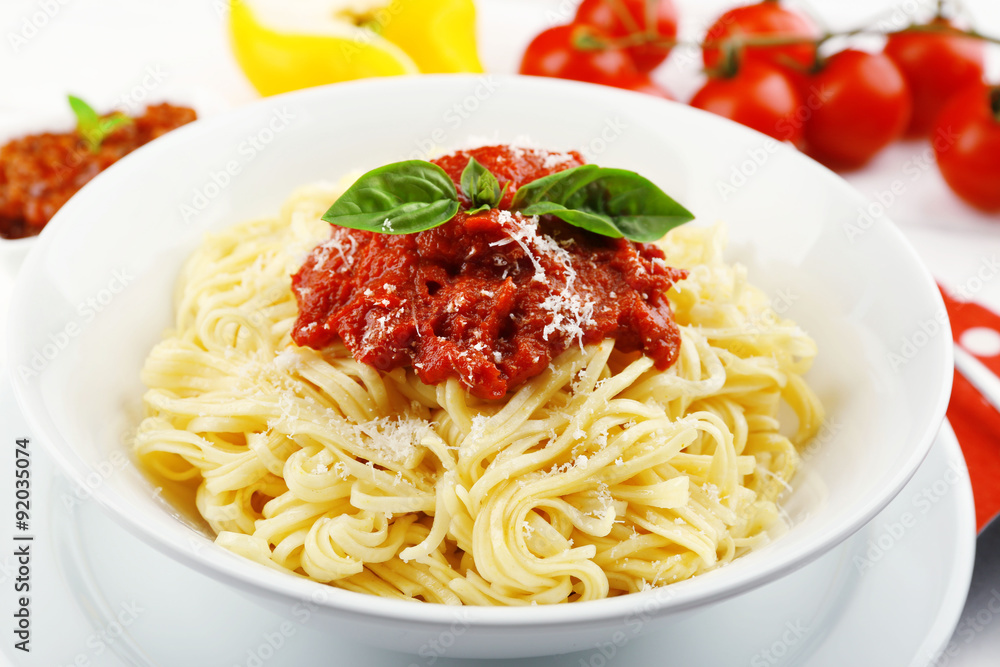 Spaghetti with tomato sauce and cheese on white plate, on color wooden background Spaghetti with tomato sauce and cheese on white plate, on color wooden background