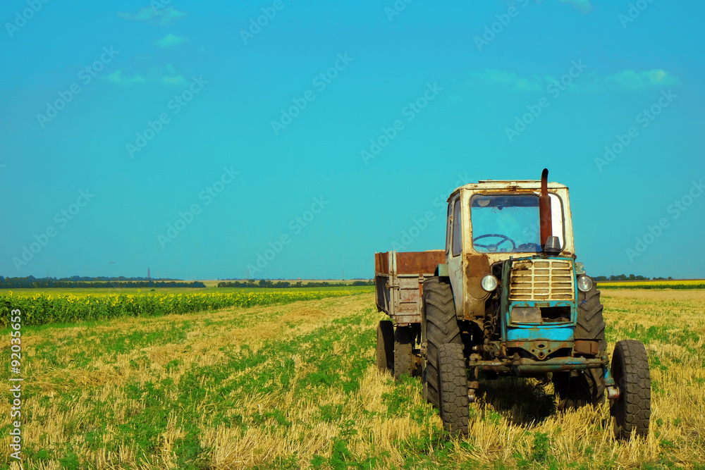 Tractor in field on blue sky background Tractor in field on blue sky background