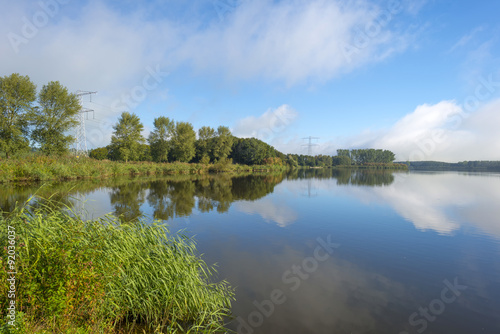 Fototapeta Naklejka Na Ścianę i Meble -  The shore of a hazy sunny lake in autumn