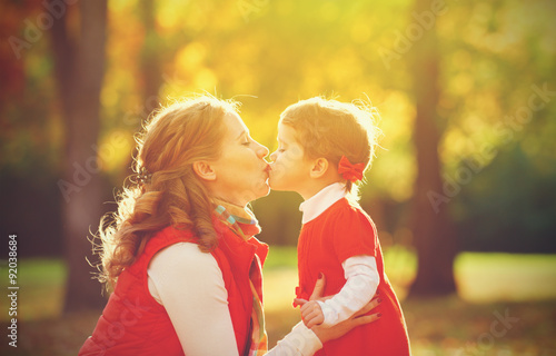 happy family. mother and child little daughter play kissing on a