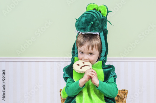 Cute child eating a Halloween cookie