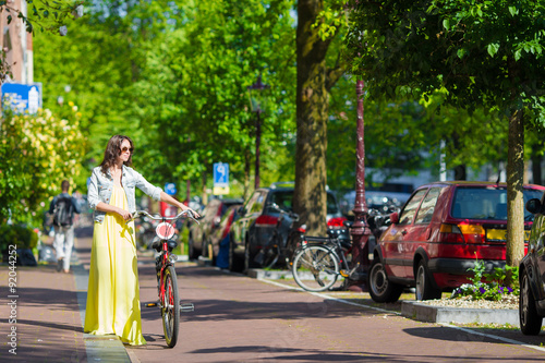 Young happy woman on bike in european city
