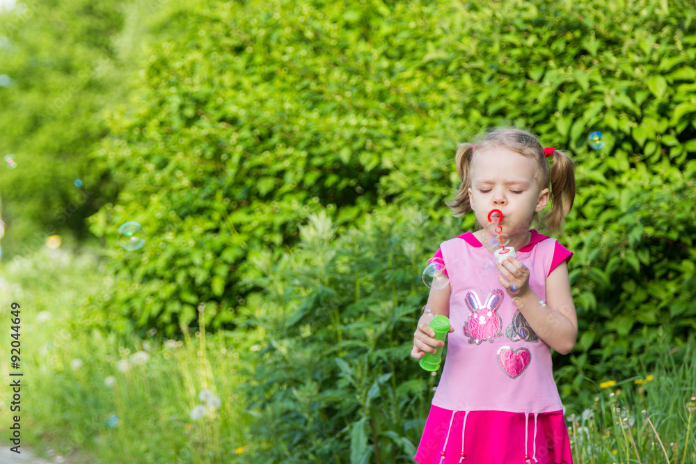 little girl with pigtails blows soap bubbles little girl with pigtails blows soap bubbles