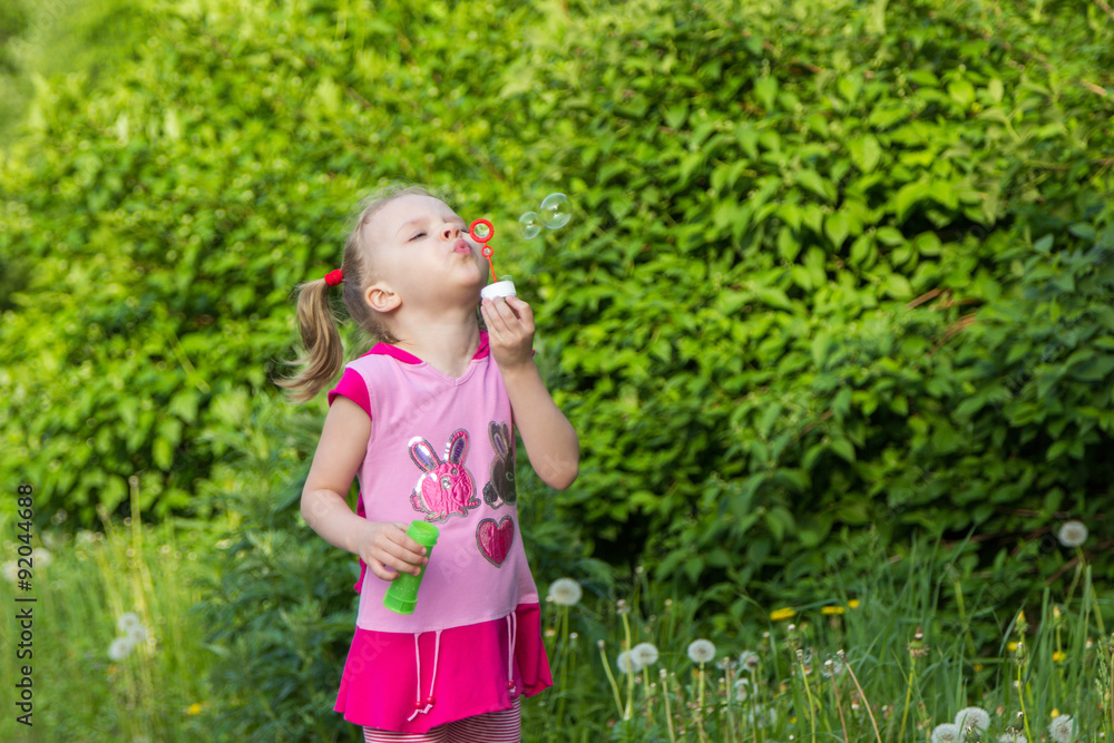 little girl with pigtails blows soap bubbles little girl with pigtails blows soap bubbles