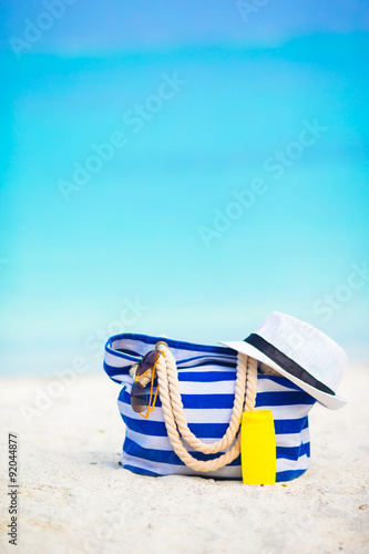Beach accessories - blue stripe bag, straw hat, sunglasses on
