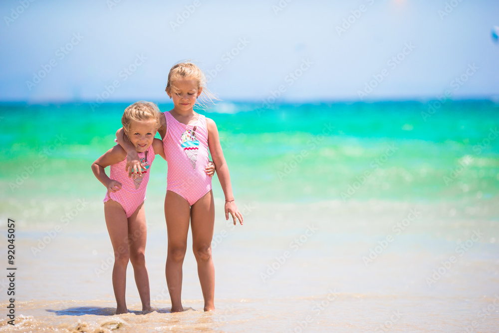 Adorable little girls having fun during beach vacation