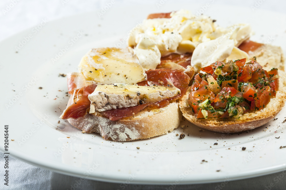 Bruschetta with prosciutto, goat cheese and fried tomatoes