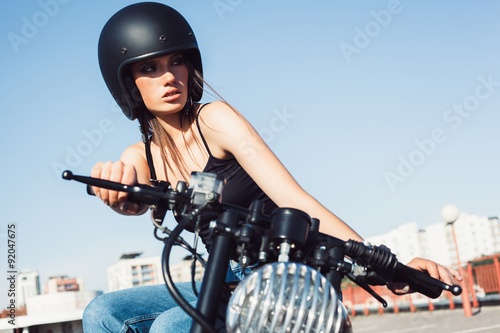 Biker girl sitting on vintage custom motorcycle photo