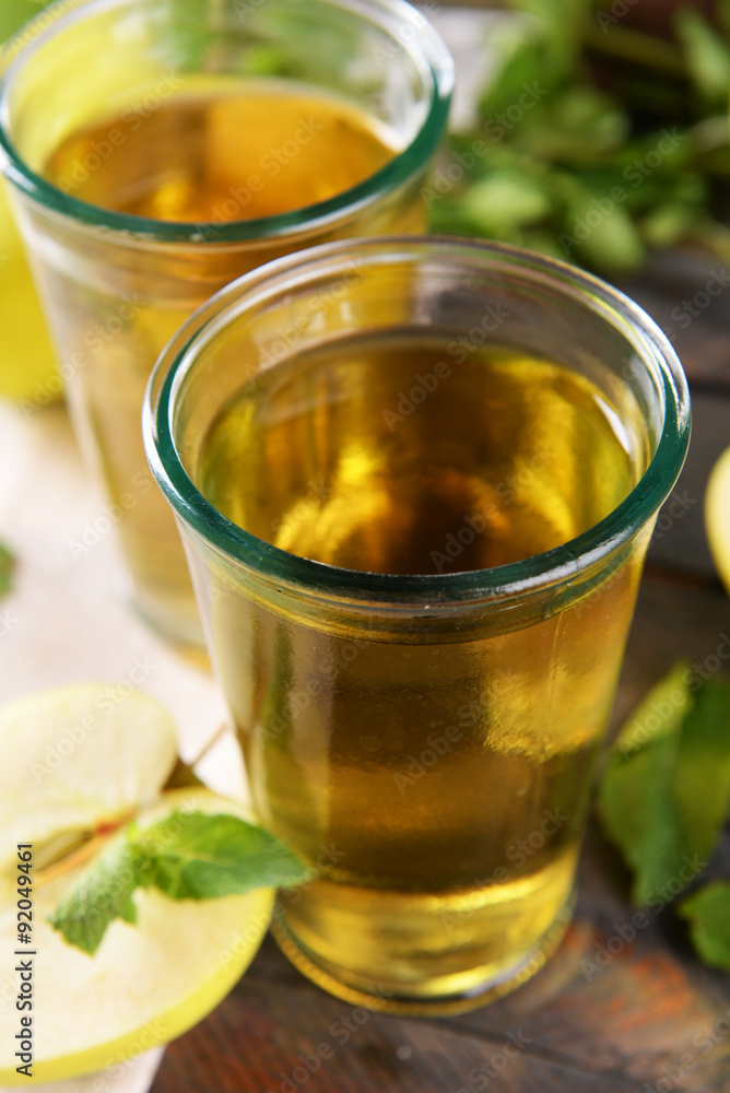Glasses of apple juice on wooden table, closeup Glasses of apple juice on wooden table, closeup