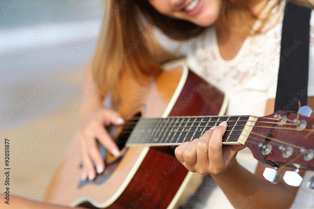 Naklejka premium Close up of a woman playing guitar on the beach