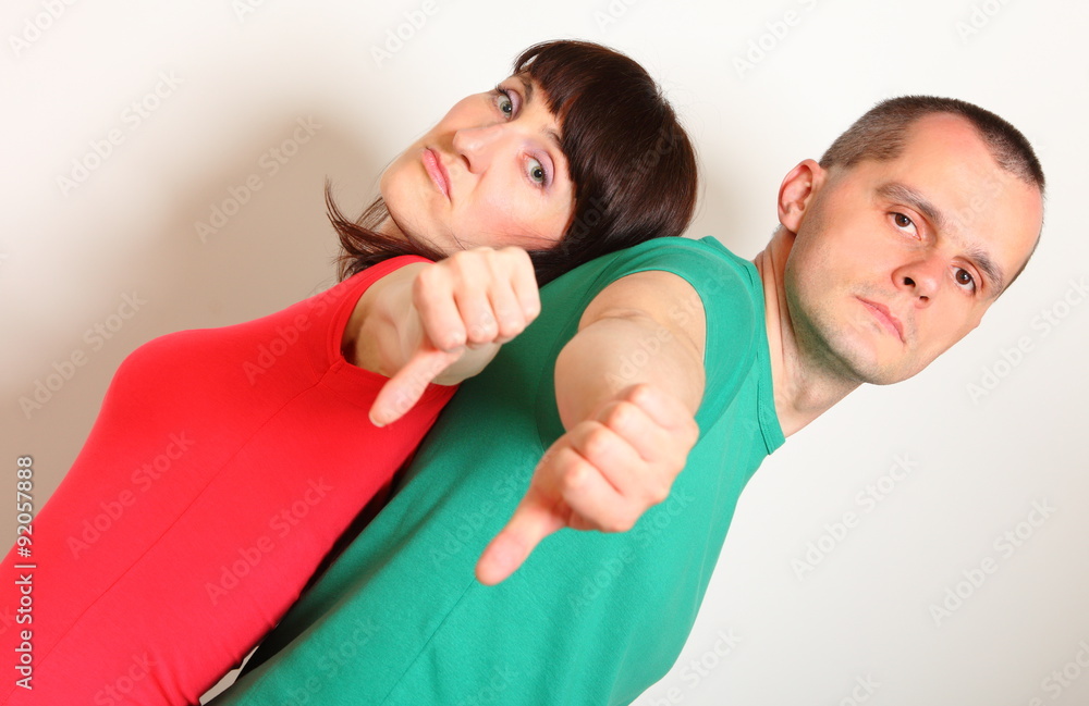 Fototapeta premium Unhappy woman and man showing thumbs down