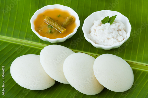 Indian idly with chutney and sambar - Fresh steamed Indian Idly (Idli / rice cake) arranged on a traditional banana leaf. Served with coconut chutney and sambar. Natural light used.