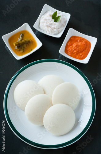 Indian idly with chutney and sambar - A traditional south Indian breakfast of fresh steamed Indian Idly (Idli / rice cake) served with tomato chutney, coconut chutney and sambar. Natural light used.