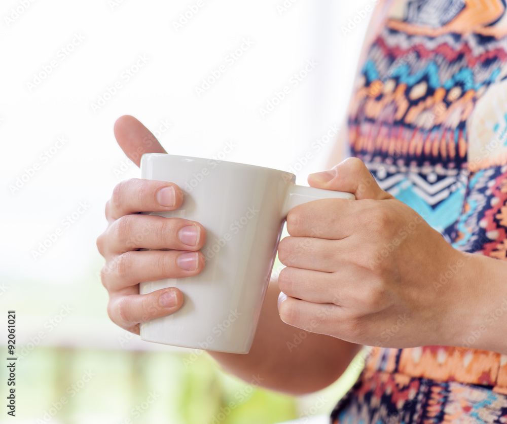 Young woman enjoying a mug of beverage. Young woman enjoying a mug of beverage.