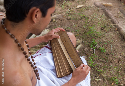 A young brahmin reads an ancient Hindu text under a banyan tree in India 

