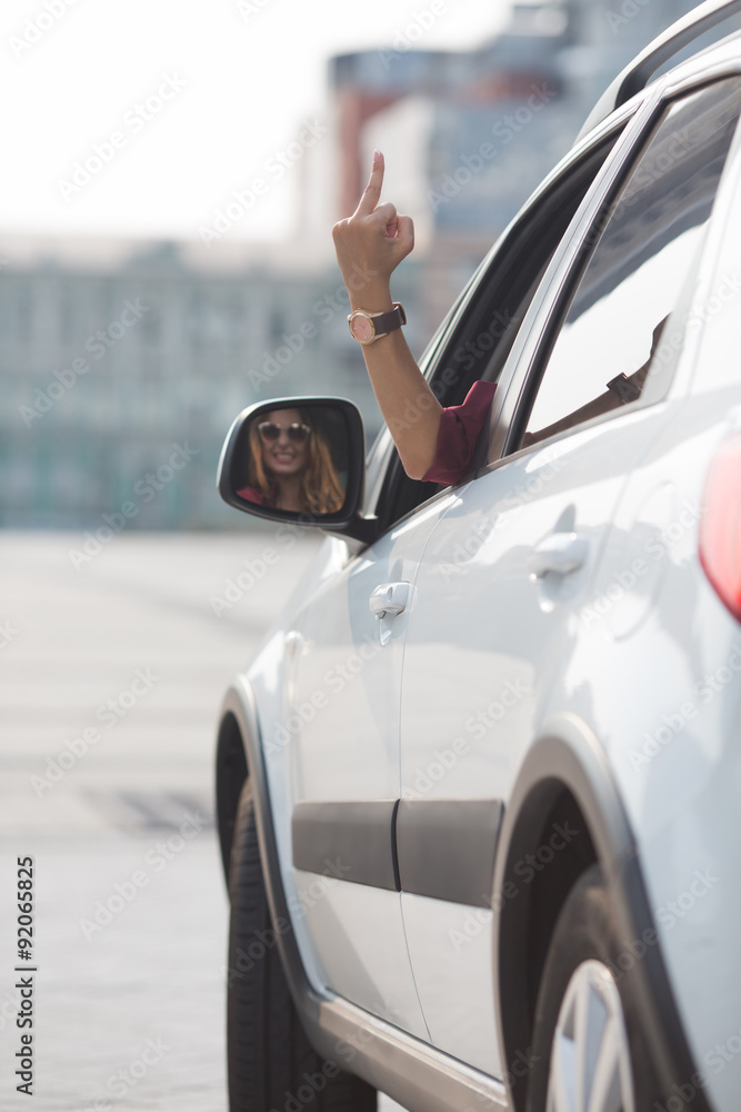 Beautiful lady showing middle finger from her car Photos