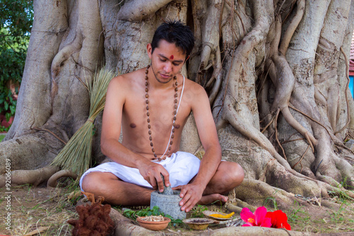 Obraz na plátně A young man preparing ayurvedic medicine in the traditional manner in India