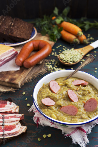 Traditional Dutch pea soup and ingredients on a rustic table