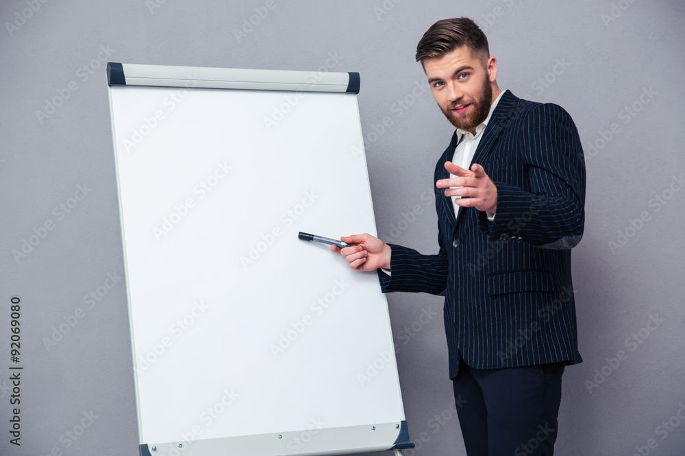 Businessman presenting something on blank board Businessman presenting something on blank board
