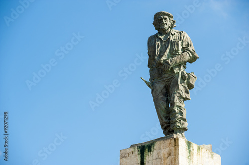 Statue of Cuban revolutionary Che Guevara stands in blue sky at a mausoleum dedicated to him and other fighters from the revolution