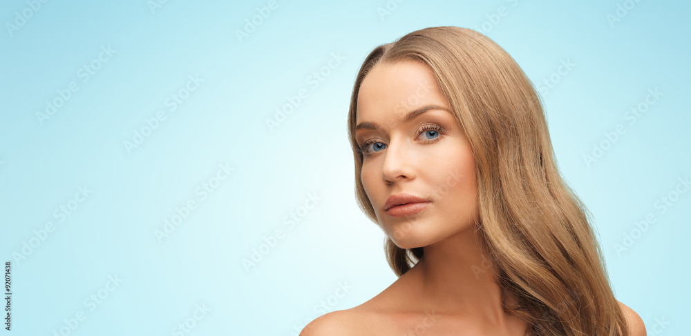 Naklejka premium beautiful young woman face over blue background