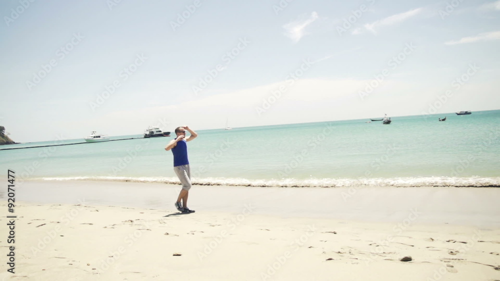 Young jogger walking and stretching on exotic beach
Young jogger walking and stretching on exotic beach