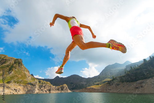 Skipping girl as he runs near a mountain lake