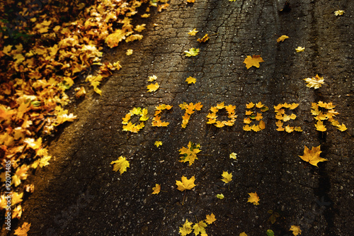 Word October made of yellow autumn leaves at asphalt background. photo