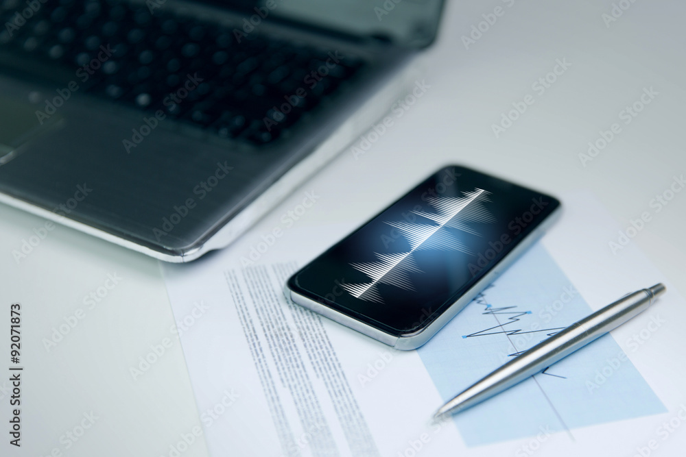 close up of smartphone, laptop and pen on table close up of smartphone, laptop and pen on table
