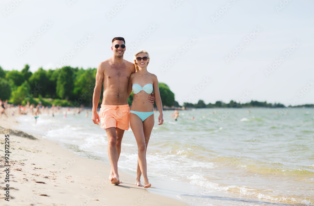 happy couple in swimwear walking on summer beach happy couple in swimwear walking on summer beach