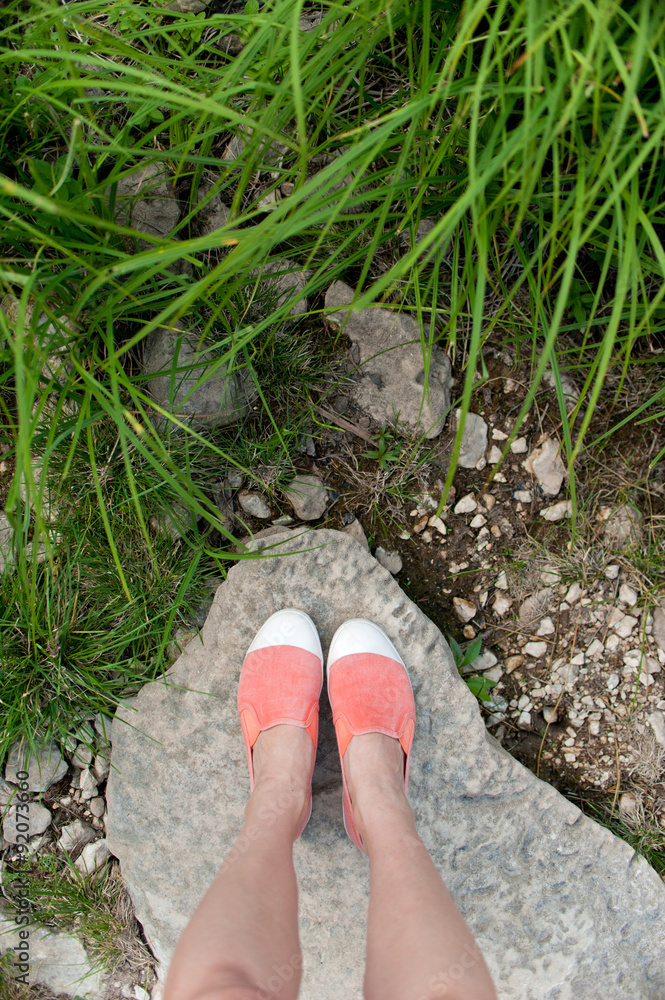Overhead photo of feet on a background of big stone and grass Overhead photo of feet on a background of big stone and grass