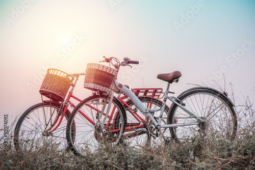 beautiful landscape image with two bicycle at sunset ; vintage f