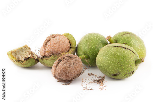 walnuts in green peel and walnuts in shell on white isolated background