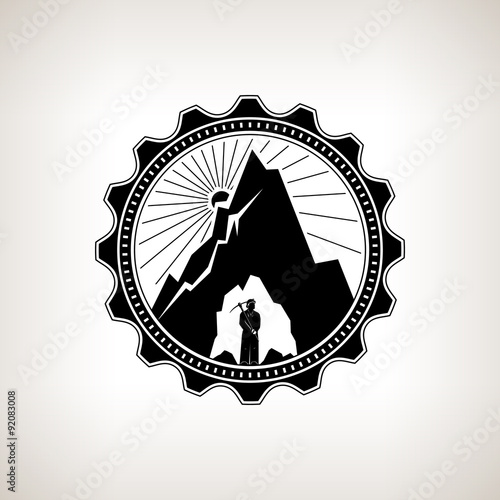 Miner in the Helmet  is Holding Pickaxe in the Bowels of the Mountain  on a Background of the Sunburst, Label or Badge Mine Shaft, Mining, Vintage Emblem of the Mining Industry