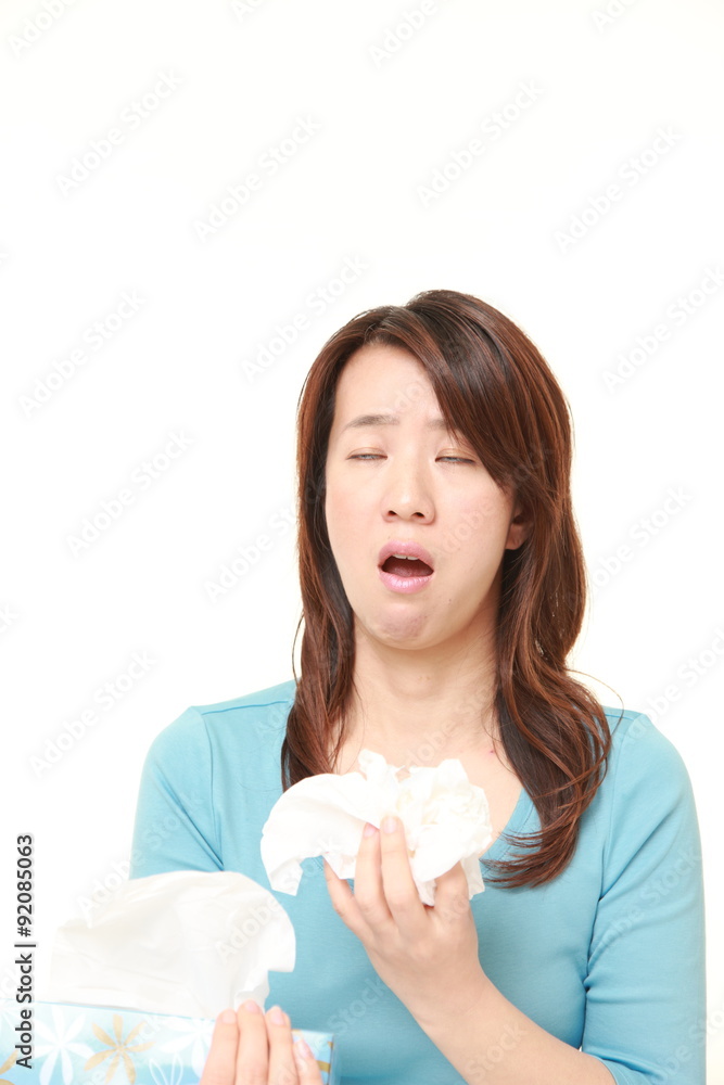 woman with an allergy sneezing into tissue woman with an allergy sneezing into tissue
