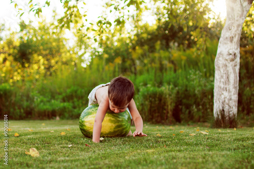 child rolling on the grass watermelon 