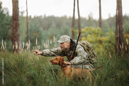 Yang Hunter z karabinem i psem w lesie